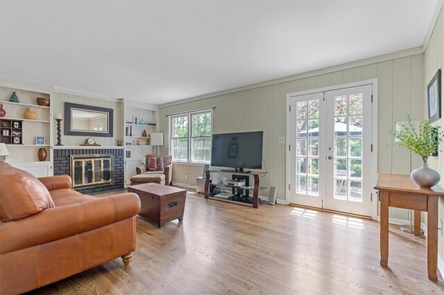 9817 Cedar St, Overland Park, KS 66207 - living room featuring wood finished floors, a brick fireplace, french doors, and built in features