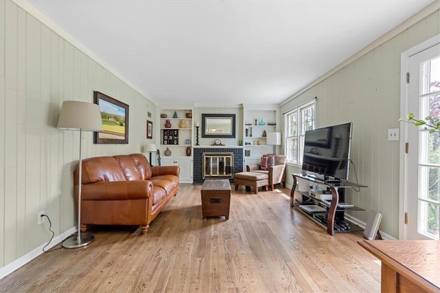 9817 Cedar St, Overland Park, KS 66207 - living room featuring wood finished floors, built in features, a brick fireplace, crown molding, and wood walls