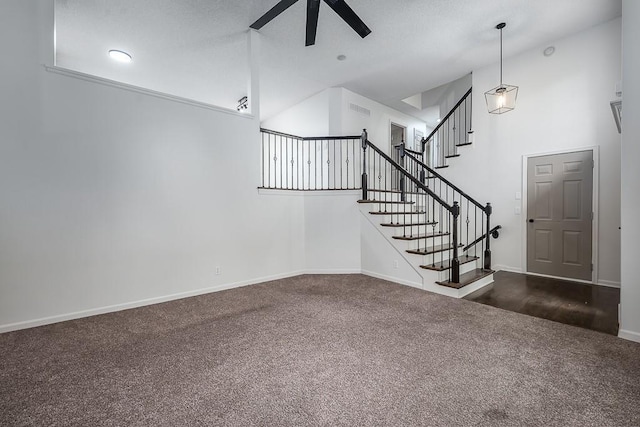 unfurnished living room featuring dark carpet, a ceiling fan, baseboards, visible vents, and stairway