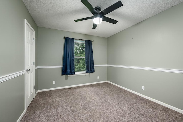 carpeted empty room with a ceiling fan, a textured ceiling, visible vents, and baseboards