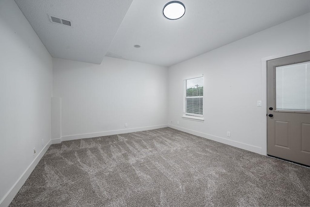 carpeted empty room featuring baseboards and visible vents