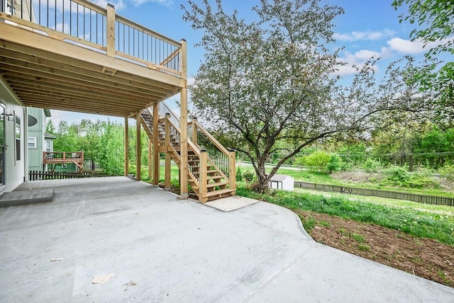 view of patio featuring an outbuilding, a wooden deck, stairs, and a storage unit