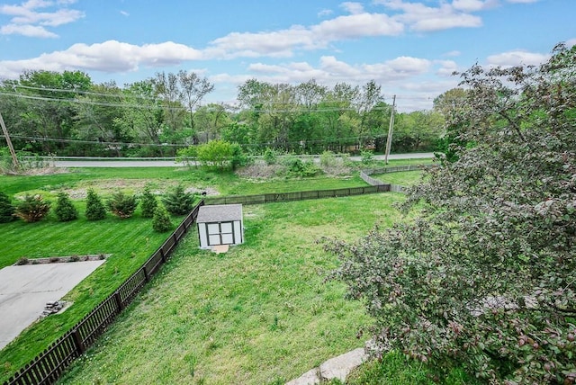 view of yard with fence, an outbuilding, and a shed