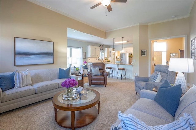 living room with light colored carpet, ornamental molding, and a ceiling fan
