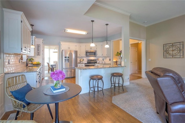 kitchen featuring a peninsula, stainless steel appliances, open floor plan, and a sink