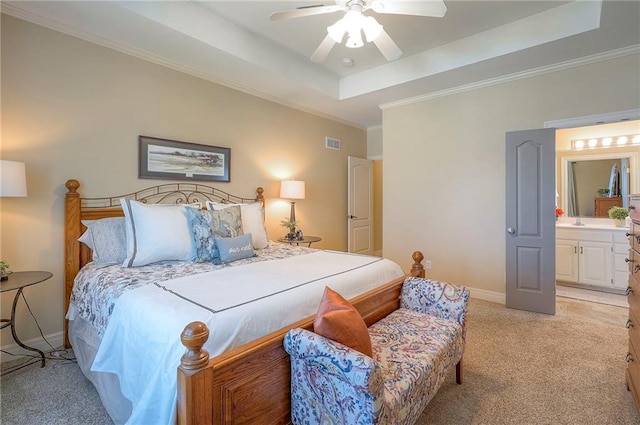 bedroom with ornamental molding, light carpet, a tray ceiling, and visible vents