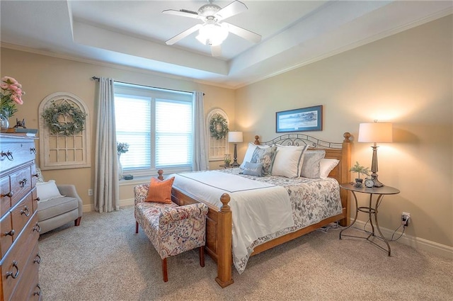 bedroom featuring light carpet, a raised ceiling, baseboards, and ornamental molding