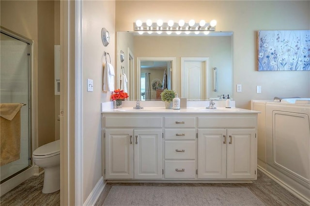full bathroom with double vanity, a stall shower, and a sink