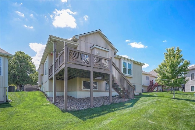 rear view of property featuring a yard, stairs, and a wooden deck