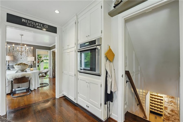 6116 W 61st Ter, Mission, KS 66202 - kitchen with oven, crown molding, dark wood-style floors, white cabinets, and a chandelier
