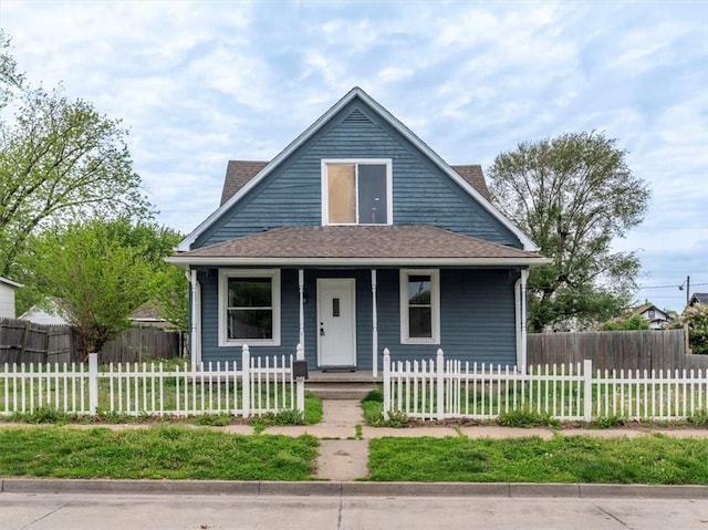 bungalow featuring a shingled roof, a porch, and a fenced front yard