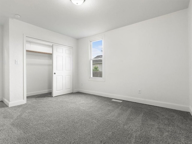 unfurnished bedroom featuring carpet floors, baseboards, visible vents, and a closet