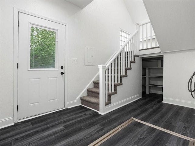 foyer featuring stairway, baseboards, and dark wood-type flooring