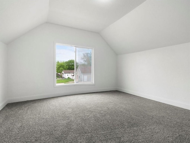 bonus room with carpet floors, baseboards, and vaulted ceiling