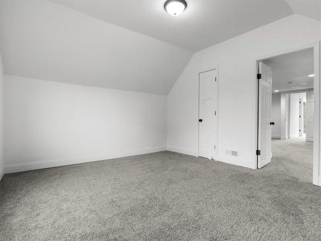 bonus room with baseboards, carpet, and vaulted ceiling