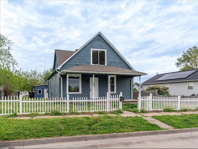 bungalow-style home featuring roof with shingles, a fenced front yard, a porch, and a front yard