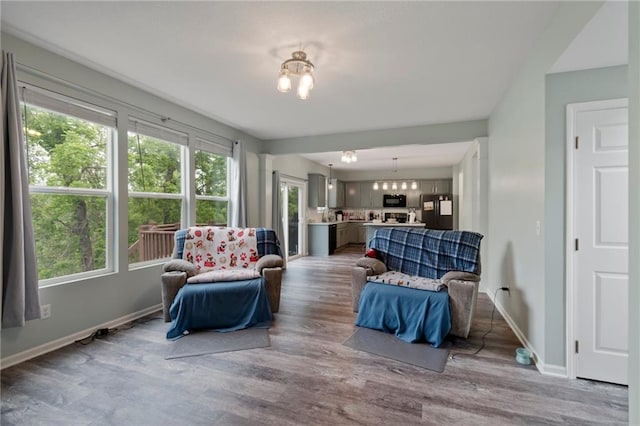7912 N Poplar Ct, Kansas City, MO 64119 - living room with wood finished floors, baseboards, and a chandelier