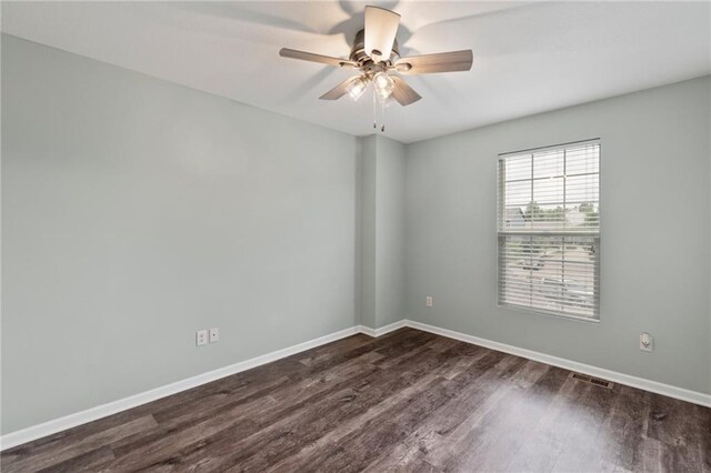 7912 N Poplar Ct, Kansas City, MO 64119 - spare room featuring dark wood-style flooring, baseboards, and ceiling fan