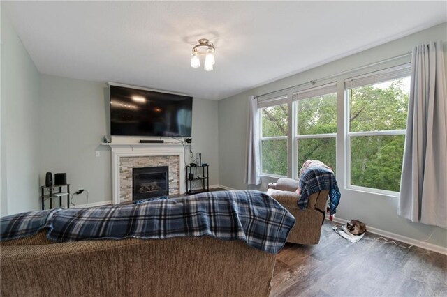 7912 N Poplar Ct, Kansas City, MO 64119 - living room featuring wood finished floors, baseboards, and a stone fireplace
