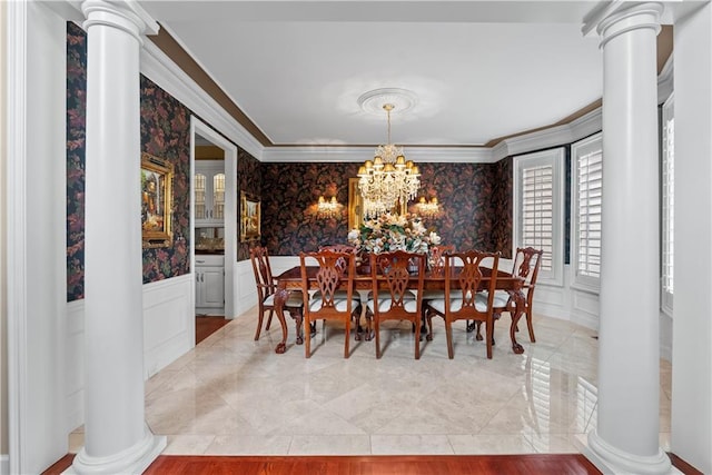 dining space featuring a decorative wall, crown molding, and ornate columns