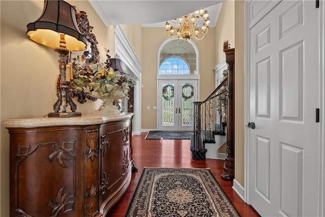 foyer with a chandelier, stairs, dark wood-style flooring, and baseboards