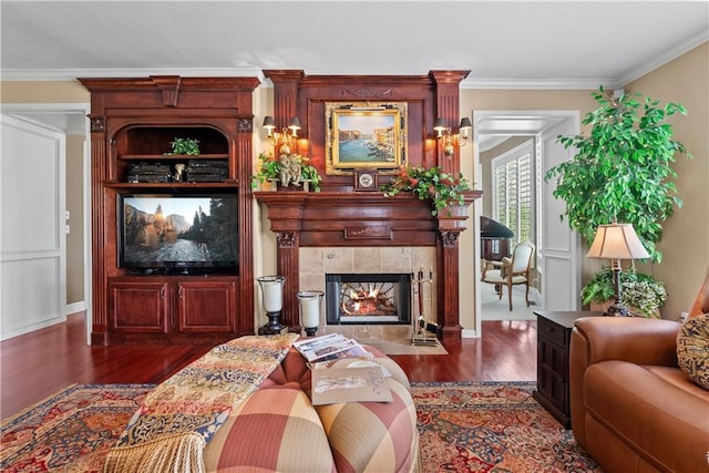 living room featuring crown molding, dark wood-type flooring, and a tiled fireplace