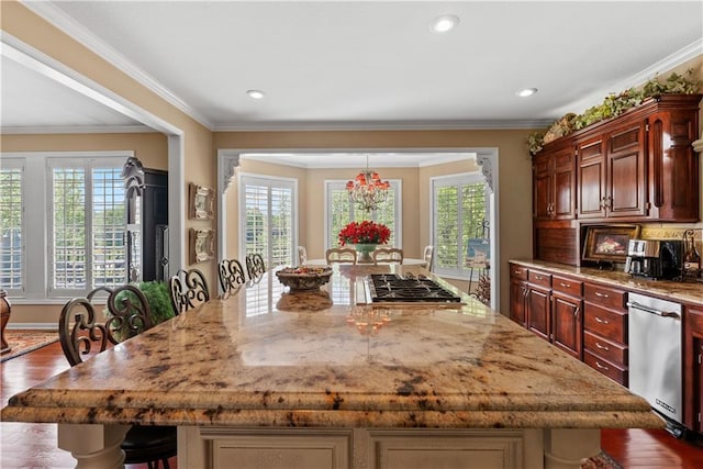 kitchen with a breakfast bar, a spacious island, light stone counters, crown molding, and appliances with stainless steel finishes