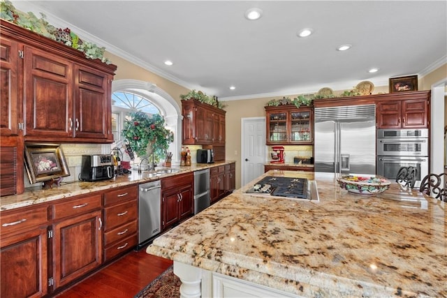 kitchen with crown molding, decorative backsplash, stainless steel appliances, and a sink