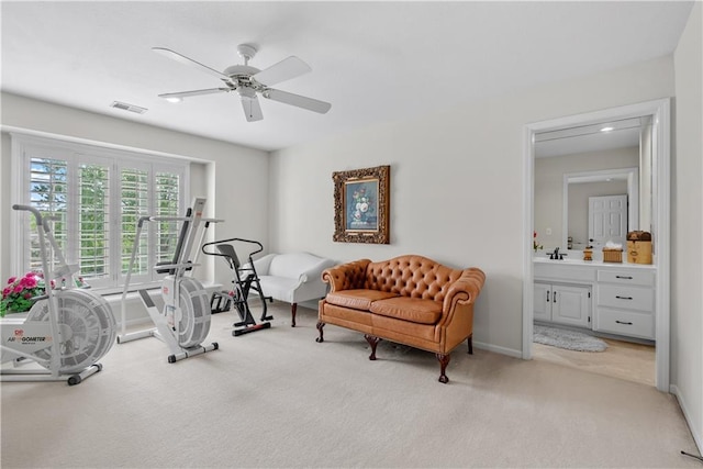 workout area with a sink, light colored carpet, visible vents, ceiling fan, and bar area