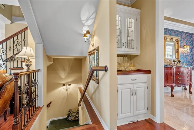 staircase featuring crown molding and baseboards