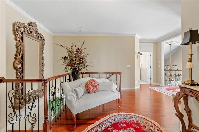 sitting room featuring baseboards, ornamental molding, and wood finished floors