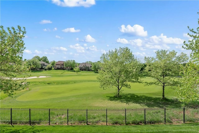 surrounding community featuring a yard, fence, and view of golf course