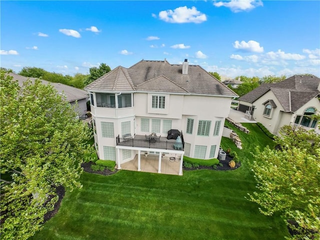 rear view of property featuring central AC unit, a patio, stucco siding, and a lawn