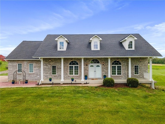 cape cod home featuring covered porch and a front yard