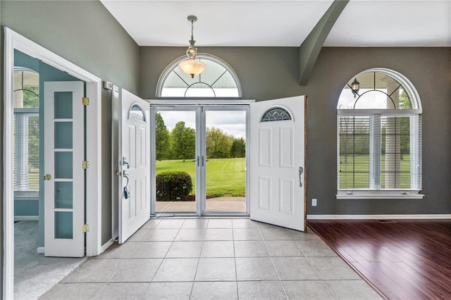 foyer featuring light tile patterned floors, baseboards, and french doors