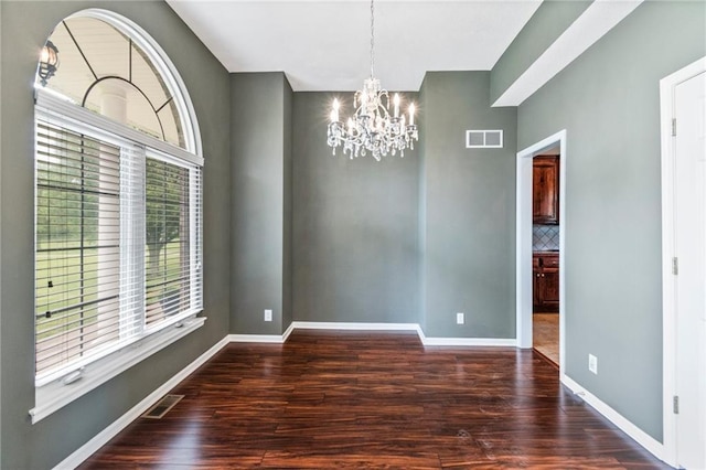 unfurnished dining area with an inviting chandelier, baseboards, wood finished floors, and visible vents