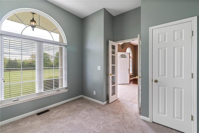 empty room featuring carpet flooring, baseboards, and visible vents