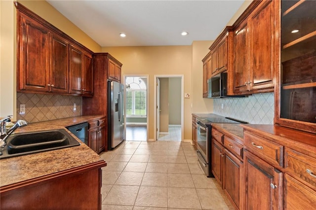 kitchen with light tile patterned flooring, baseboards, a sink, appliances with stainless steel finishes, and backsplash