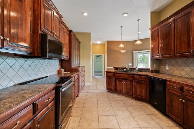 kitchen with dark countertops, appliances with stainless steel finishes, decorative backsplash, and a sink