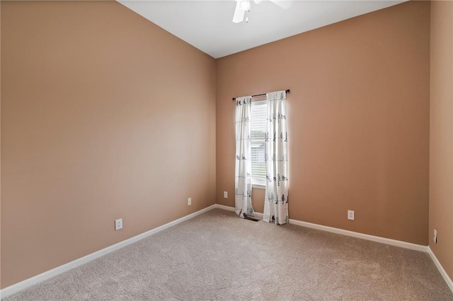 carpeted spare room with baseboards and ceiling fan
