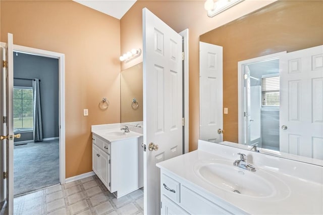 bathroom with two vanities, tile patterned floors, a healthy amount of sunlight, and a sink