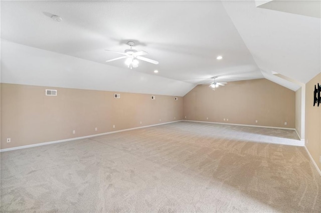 bonus room with a ceiling fan, light colored carpet, visible vents, vaulted ceiling, and baseboards