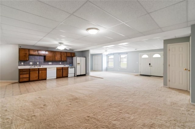 kitchen with ceiling fan, light carpet, white appliances, light countertops, and brown cabinetry