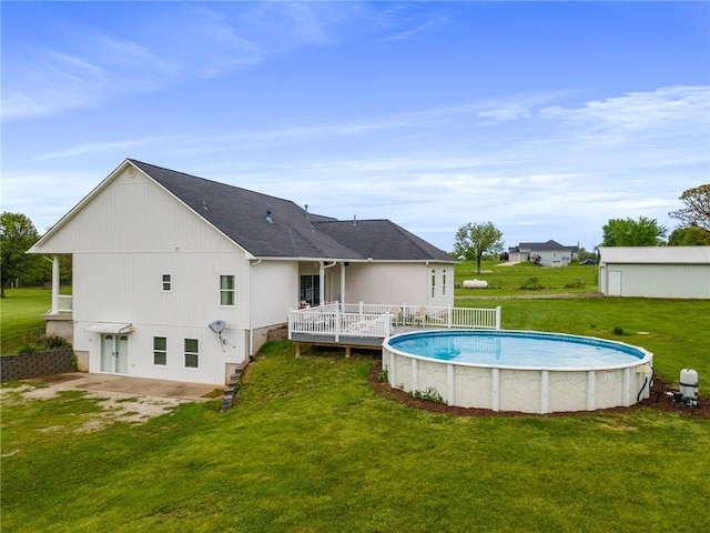 outdoor pool with a lawn and a deck