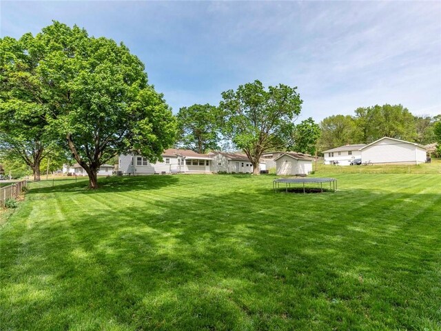 view of yard featuring fence and a trampoline