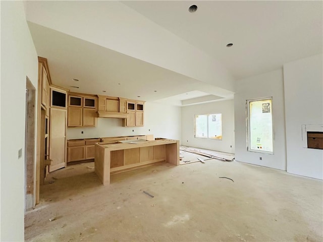 200 E Maple St, Lone Jack, MO 64070 - kitchen with open floor plan, a center island, light brown cabinets, and glass insert cabinets