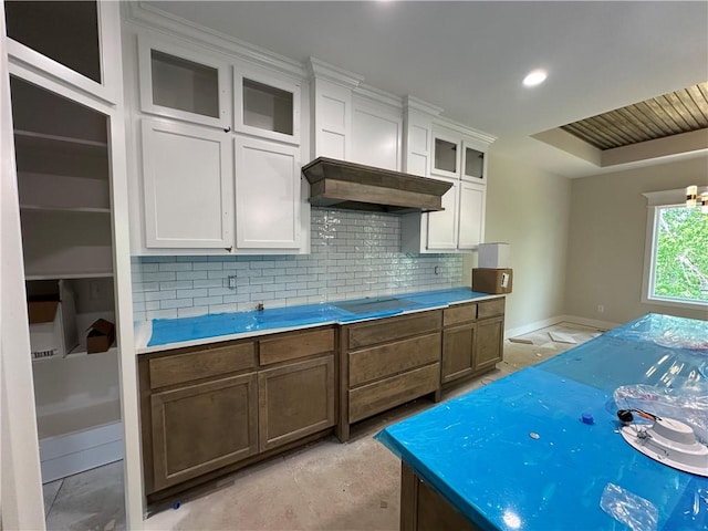 200 E Maple St, Lone Jack, MO 64070 - kitchen featuring tasteful backsplash, white cabinetry, glass insert cabinets, and light countertops