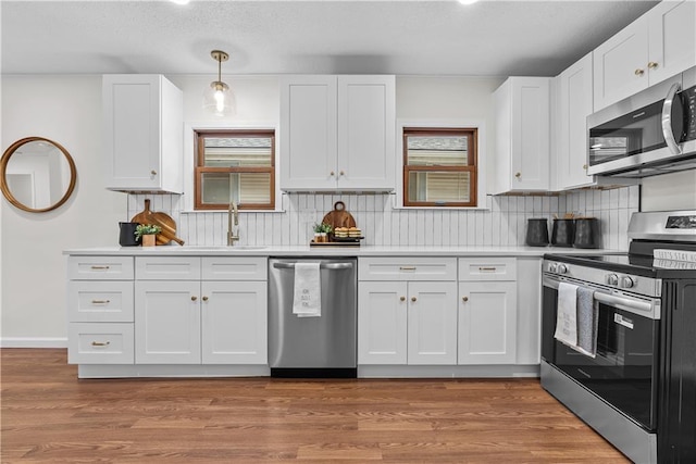 2521 W 47th Ter, Westwood, KS 66205 - kitchen with appliances with stainless steel finishes, plenty of natural light, white cabinets, and a textured ceiling