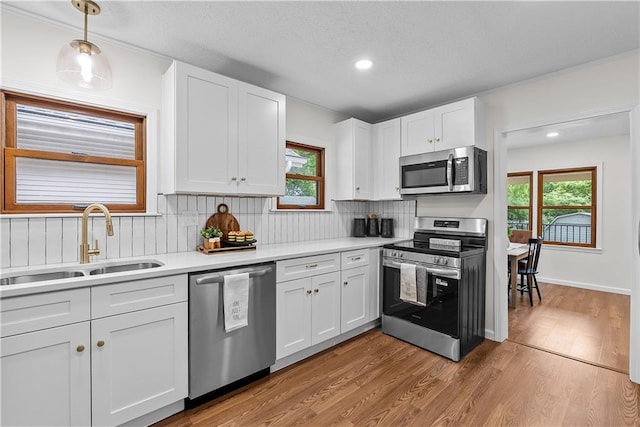 2521 W 47th Ter, Westwood, KS 66205 - kitchen with appliances with stainless steel finishes, a sink, decorative backsplash, white cabinetry, and light countertops