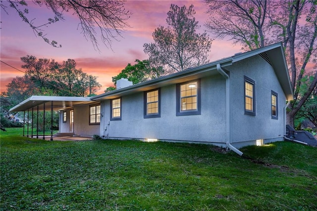 rear view of house with a yard, a chimney, a patio area, and stucco siding